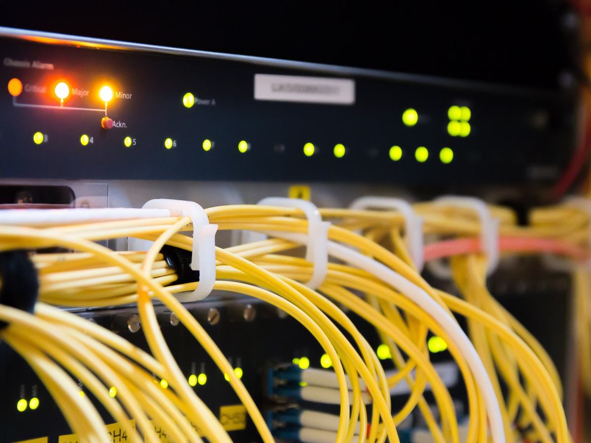 Nätverkskablar kopplade till en switch i ett serverskåp